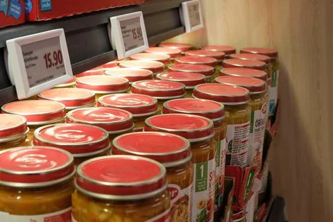 A row of red jars with white labels on them Stock Photos