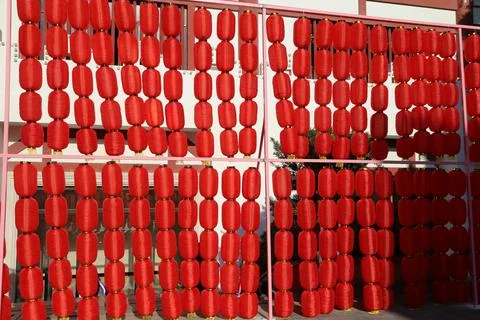 A row of red lanterns, all the same size and shape, hanging on metal frames.. Foto stock