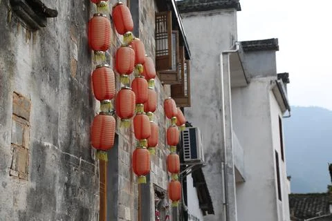 A row of red lanterns hung on the walls, with white buildings in the style .. Stock Photos