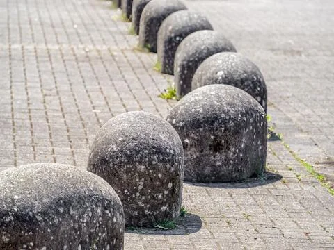 Row of Rounded Stone Bollards on Paved Surface Foto stock