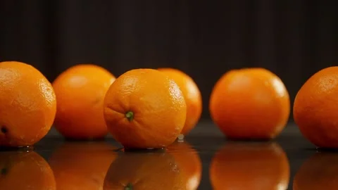 Row of seedless Rangpur oranges on table, black background Stock Footage 268280554