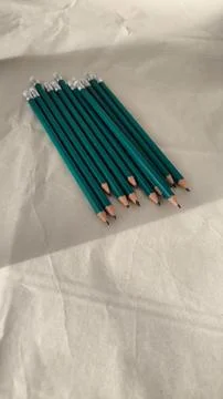 Row of sharpened green graphite pencils on paper 스톡 사진