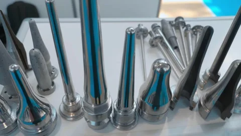 A row of shiny, chrome-plated elements for blowing glass and plastic bottles Video stock 333363816
