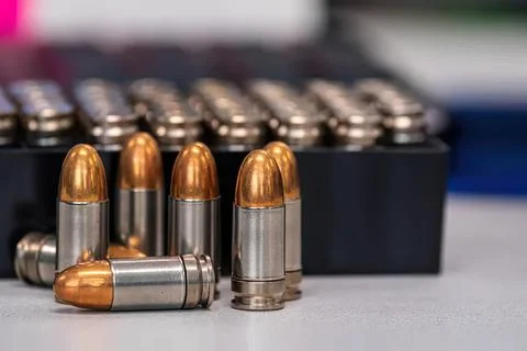 A row of shiny copper and silver bullets on a table Stock Photos