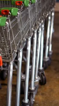 Row of shopping carts lined up in retail store with shiny metal frames Stock Photos