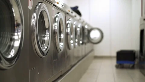 Row of silver washing machines in a Laundry Stockbeeldmateriaal 113689726