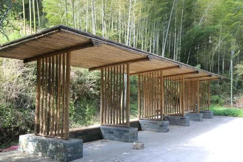 A row of simple wooden structures made from bamboo and stone, arranged in a.. Stock Photos