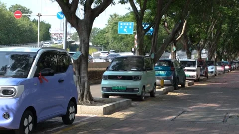 A row of small, compact electric Wuling Hongguang and Baojun mini-EVs in China Vídeos de archivo 289583693