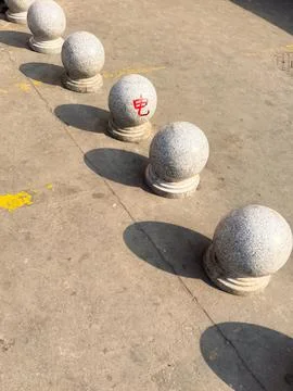 A row of small spherical granite bollards lining a pedestrian area in China Stock Photos