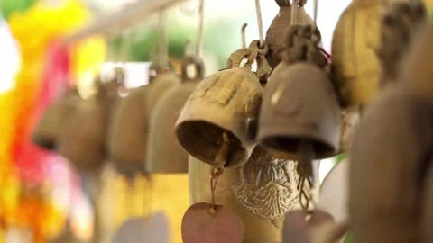 A row of small traditional Buddhist temple bells hanging on a metal bar. 動画素材 336982621