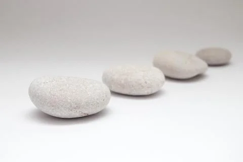 A row of smooth pebbles on white background Stock Photos