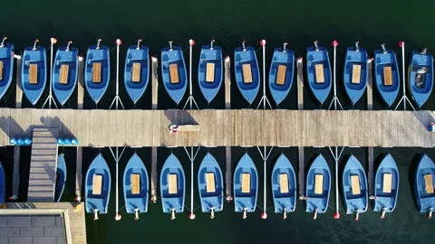 Row of solar panel electrical dinghy tied to a bridge aerial video Stock Footage 235449824