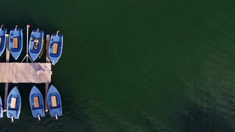 Row of solar panel powered dinghy tied to a bridge aerial video Stock Footage 235449853