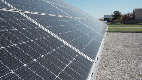 Row of solar panels on ground generate electricity from sun near house Stock Footage 333981913