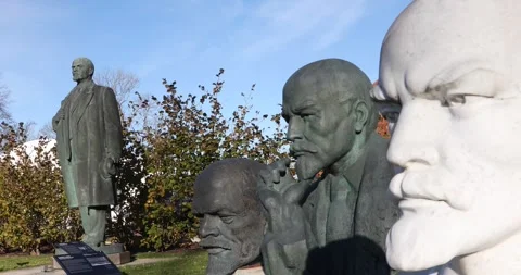 Row of Soviet-era leader statues in a sunny outdoor sculpture park Stock Footage 321049098