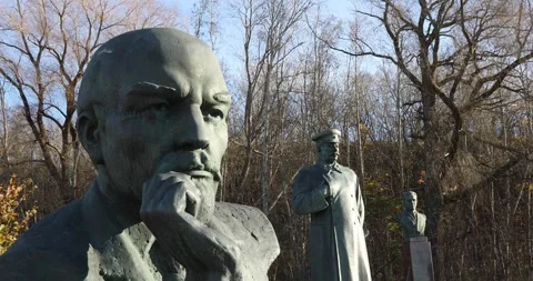 Row of Soviet-era leader statues in a sunny outdoor sculpture park Stock Footage 321049107