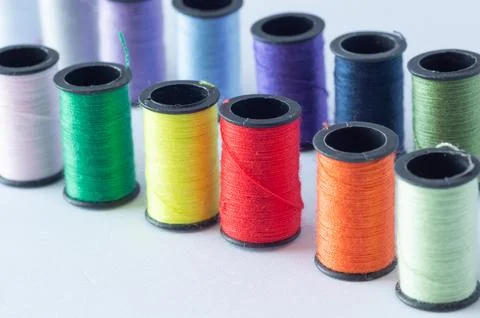 A row of spools of colored thread for the background. Stock Photos