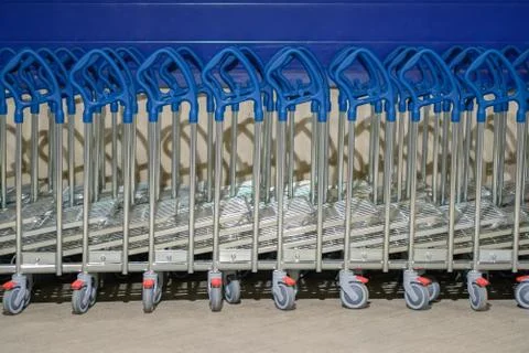 Row of stacked freight heavy load shopping carts with blue handles in front.. Stock Photos