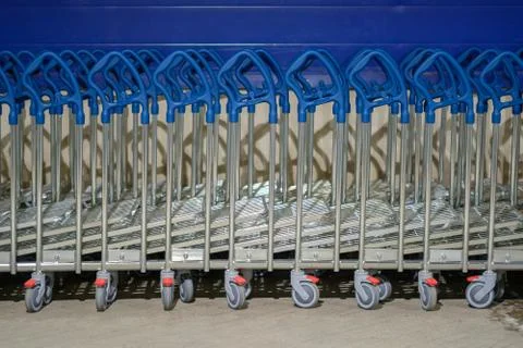 Row of stacked freight heavy load shopping carts with blue handles in front.. Stock Photos
