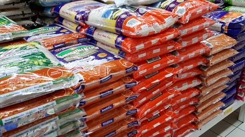 Row of stacked rice in a package displayed for sale in a supermarket Stock Footage 100322638