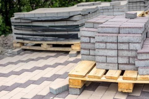 Row of stacks of gray pavement slab on wooden base . Concrete stone paving fl Stock Photos