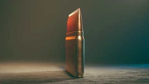 Row of standing .50 BMG machine gun cartridges. New, metallic ammunition. 4K Stock Footage 110081788