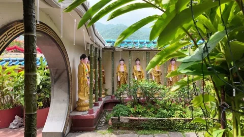 A row of statues of Buddha are lined up in a courtyard at Kek Lok Si Temple Video stock 318092879
