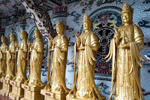 A row of statues of Buddha are lined up in a row Stock Photos