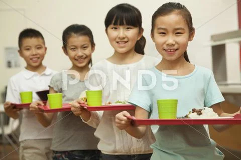 Row of students standing in line in school cafeteria Stock Photos
