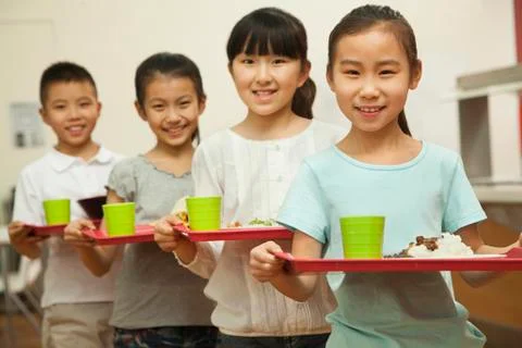 Row of students standing in line in school cafeteria Stock Photos