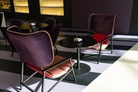 A row of tables with soft comfortable violet chairs for visitors to the food  Stock Photos