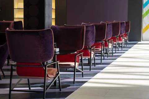 A row of tables with soft comfortable violet chairs for visitors to the food  Stock Photos