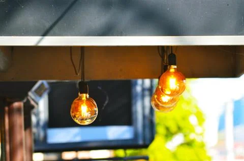 A row of three light bulbs hanging from a ceiling. Foto stock