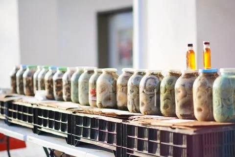A row of three-liter jars of pickled mushrooms for sale under the sun Foto stock