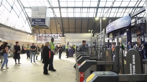 Row of Ticket Gates and Commuters Passing Through at British Railway Station Stock Footage 119145966