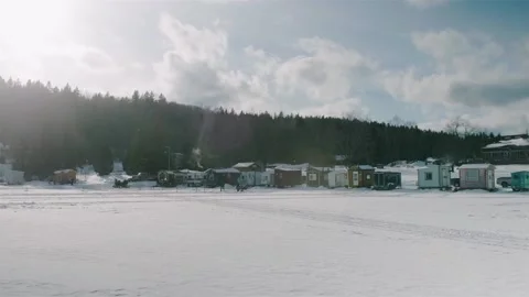 Row Of Tiny Ice Fishing Huts On Frozen Lake Megantic In Quebec. Slow Motion Stock Footage 153444029