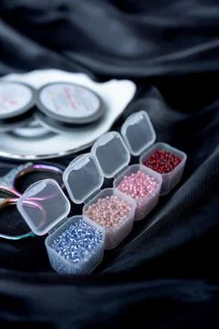 A row of transparent boxes with beads are interconnected on a dark background Stock Photos