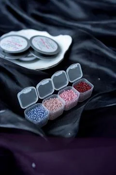 A row of transparent boxes with beads are interconnected on a dark background Stock Photos