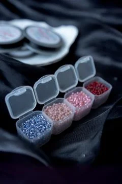 A row of transparent boxes with beads are interconnected on a dark background Stock Photos