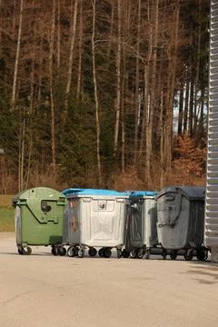 A row of trash cans are lined up on the street Stock Photos