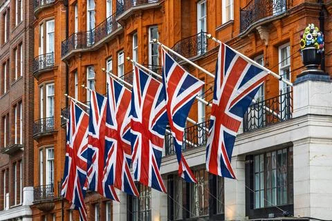 Row of Union Jack Flags Displayed on Classic London Building Stock Photos