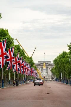A row of Union Jack flags hanging along the Mall in London up to Buckingham P Stock Photos