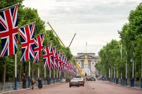 A row of Union Jack flags hanging along the Mall in London up to Buckingham P Stock Photos
