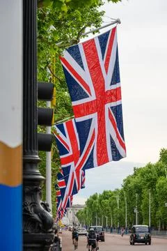 A row of Union Jack flags hanging along the Mall in London up to Buckingham P Stock Photos