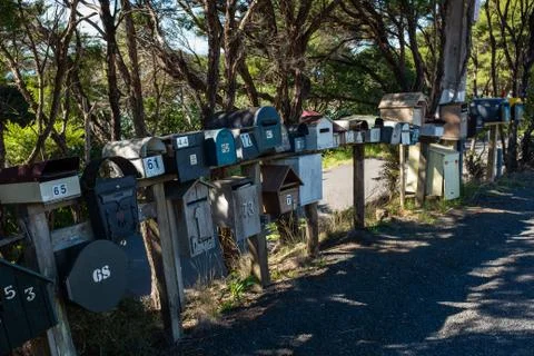 A row of various shaped and sized mail boxes by the side of the road in rural Stock Photos