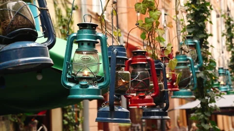 A row of vintage, rustic, multi-colored kerosene lamps hang in a row and swaying Stock Footage 291274428