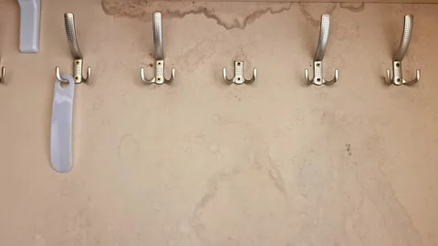 Row of Wall Hooks on Beige Textured Surface with Staining 動画素材 331375655