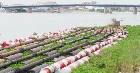 Row of water pipes running  parallel to the riverbank Stock Footage 256282183