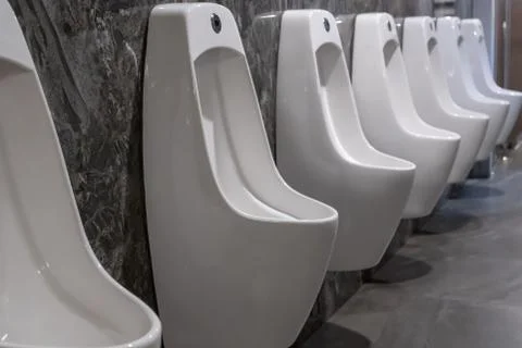 Row of white ceramic urinal chamber pot interior design with beautiful marble Stock Photos