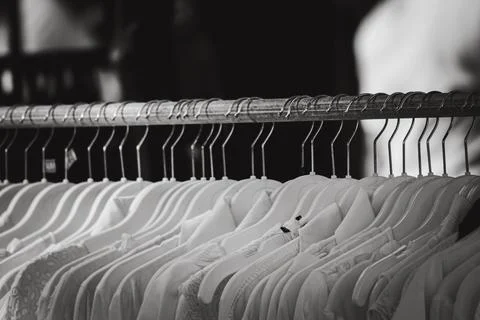 A row of white clothes hanging on a rack Stock Photos